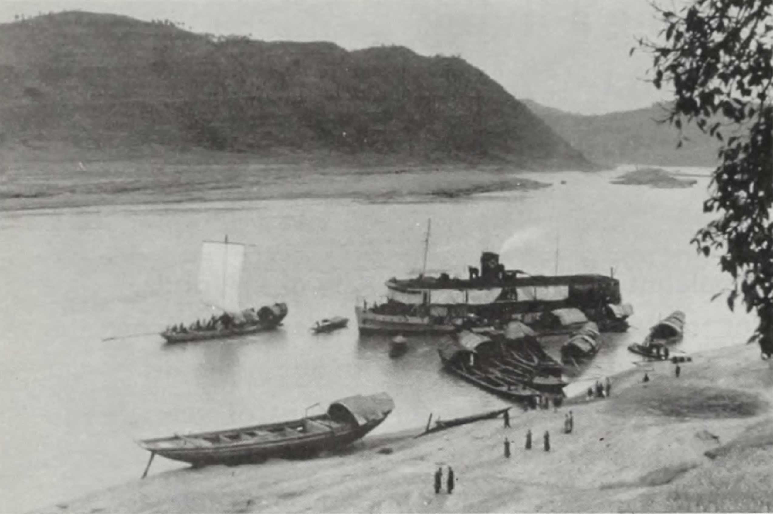 Black-and-white landscape image showing river with boats