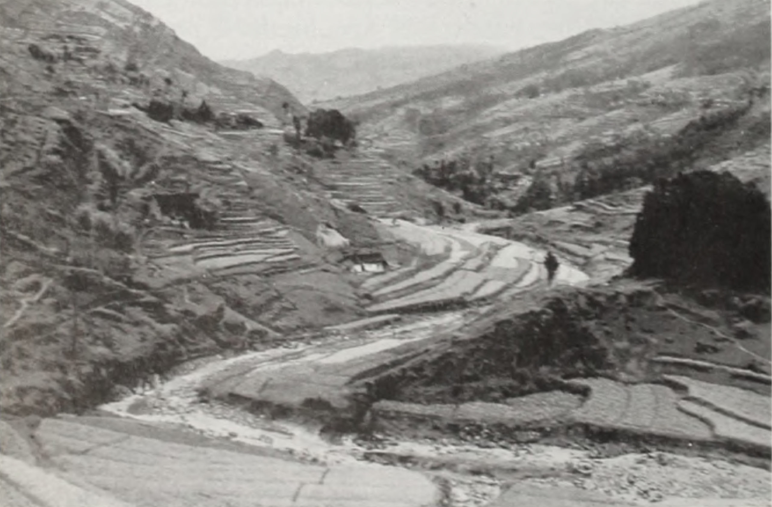Black-and-white landscape image showing river snaking between mountains