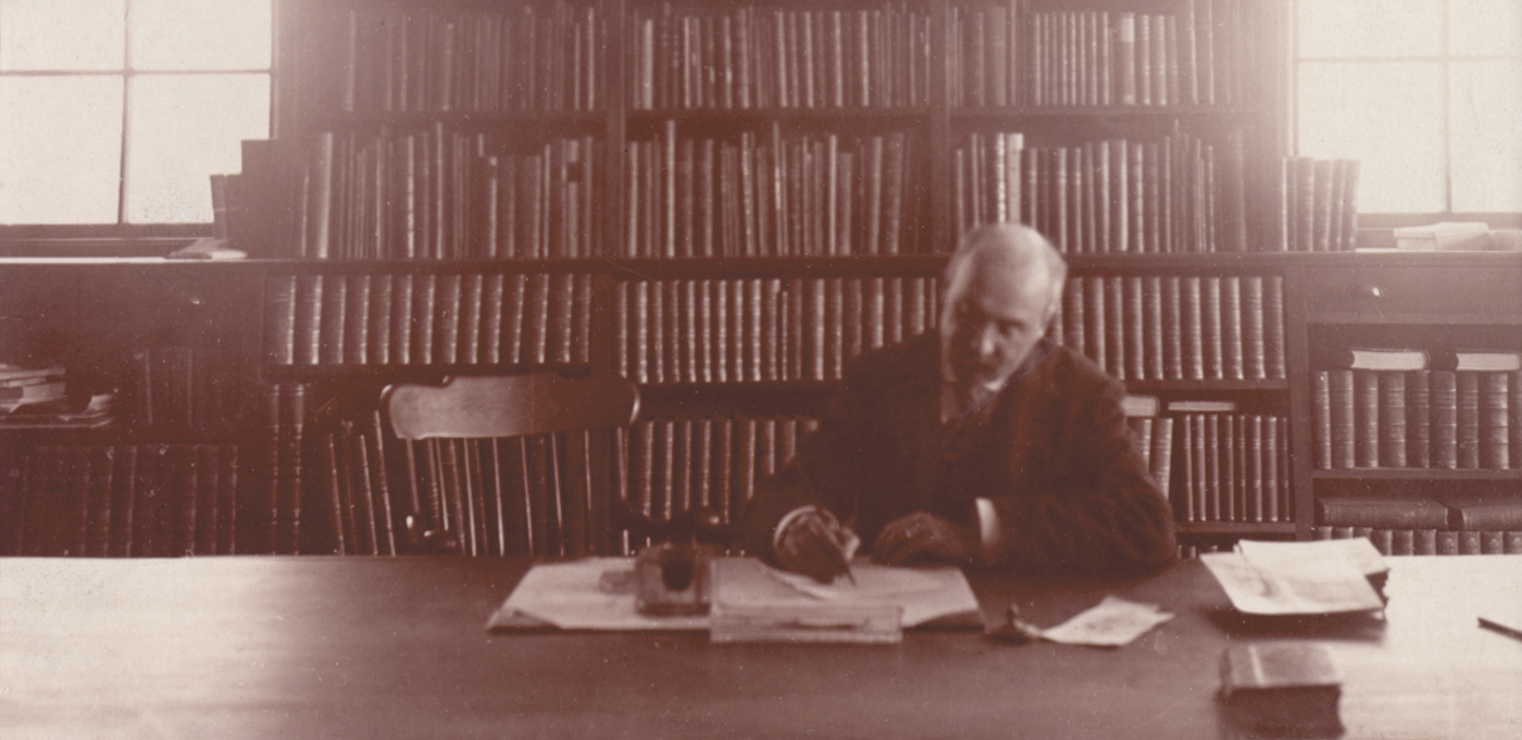 Sepia photograph of botanist working at table in library