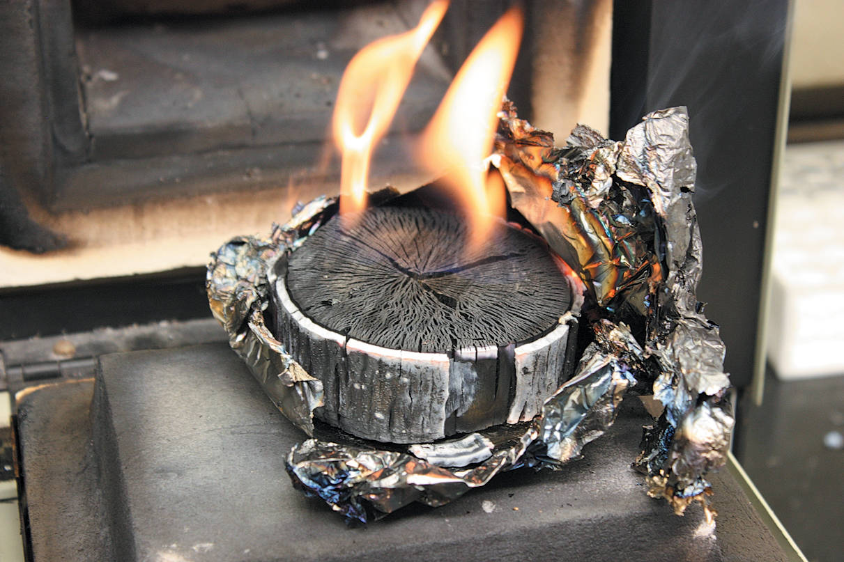 A color photo of burning, carbonized wood.