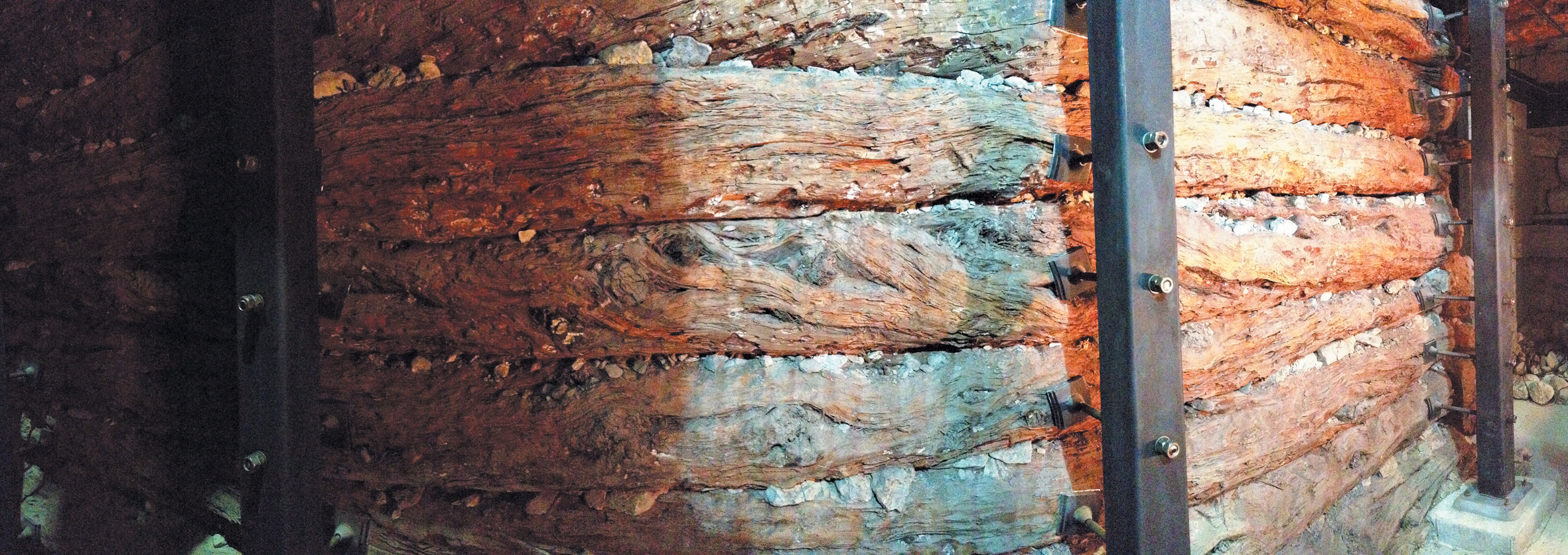 A color photo of a wall of juniper logs.