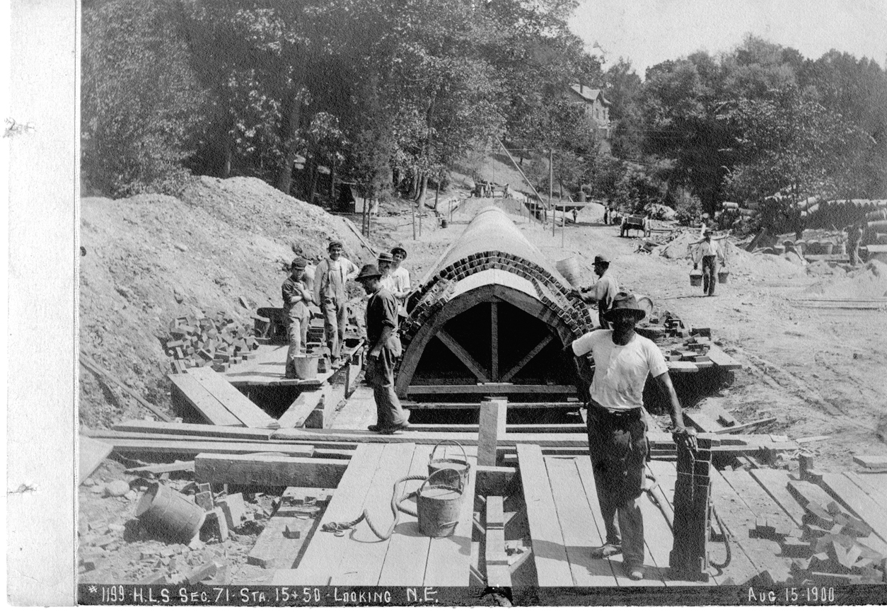 A black and white photo of a sewer line being installed.