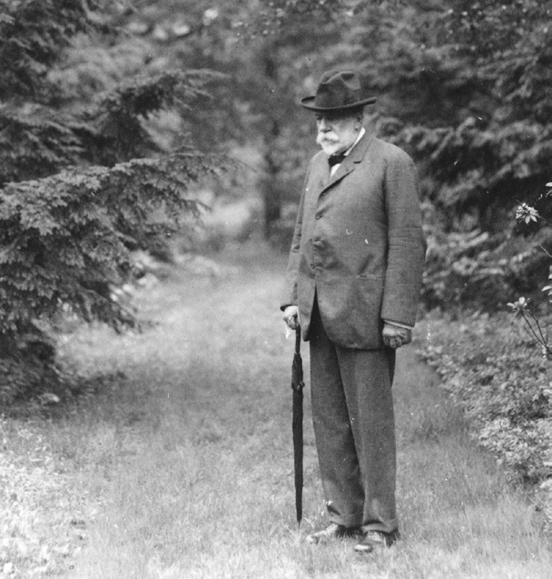 Black-and-white photograph of man standing on grass path