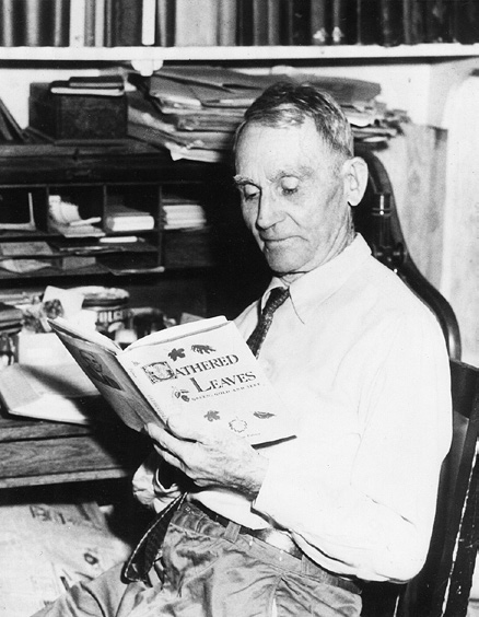 Black-and-white photograph of man holding book