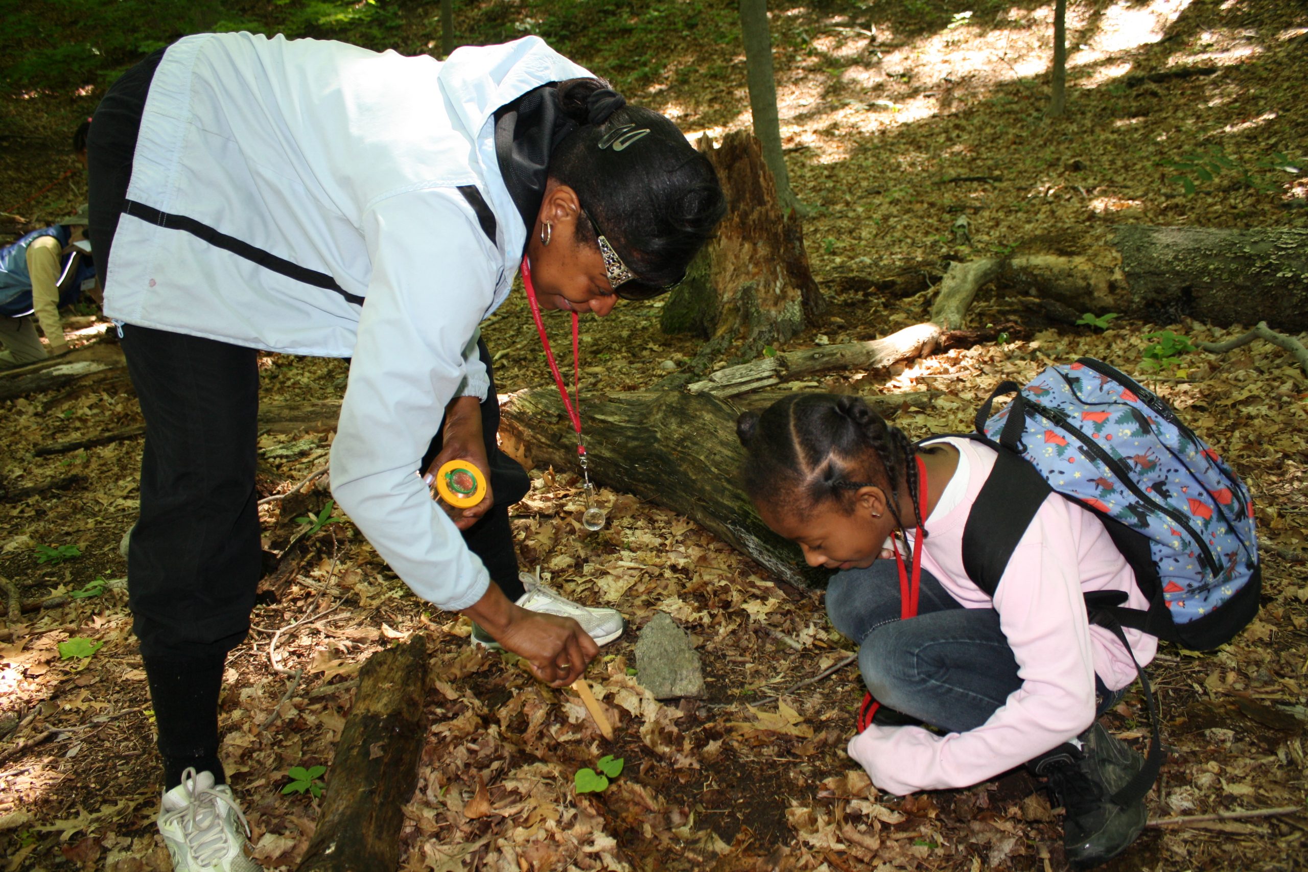 A teacher and student examine insects