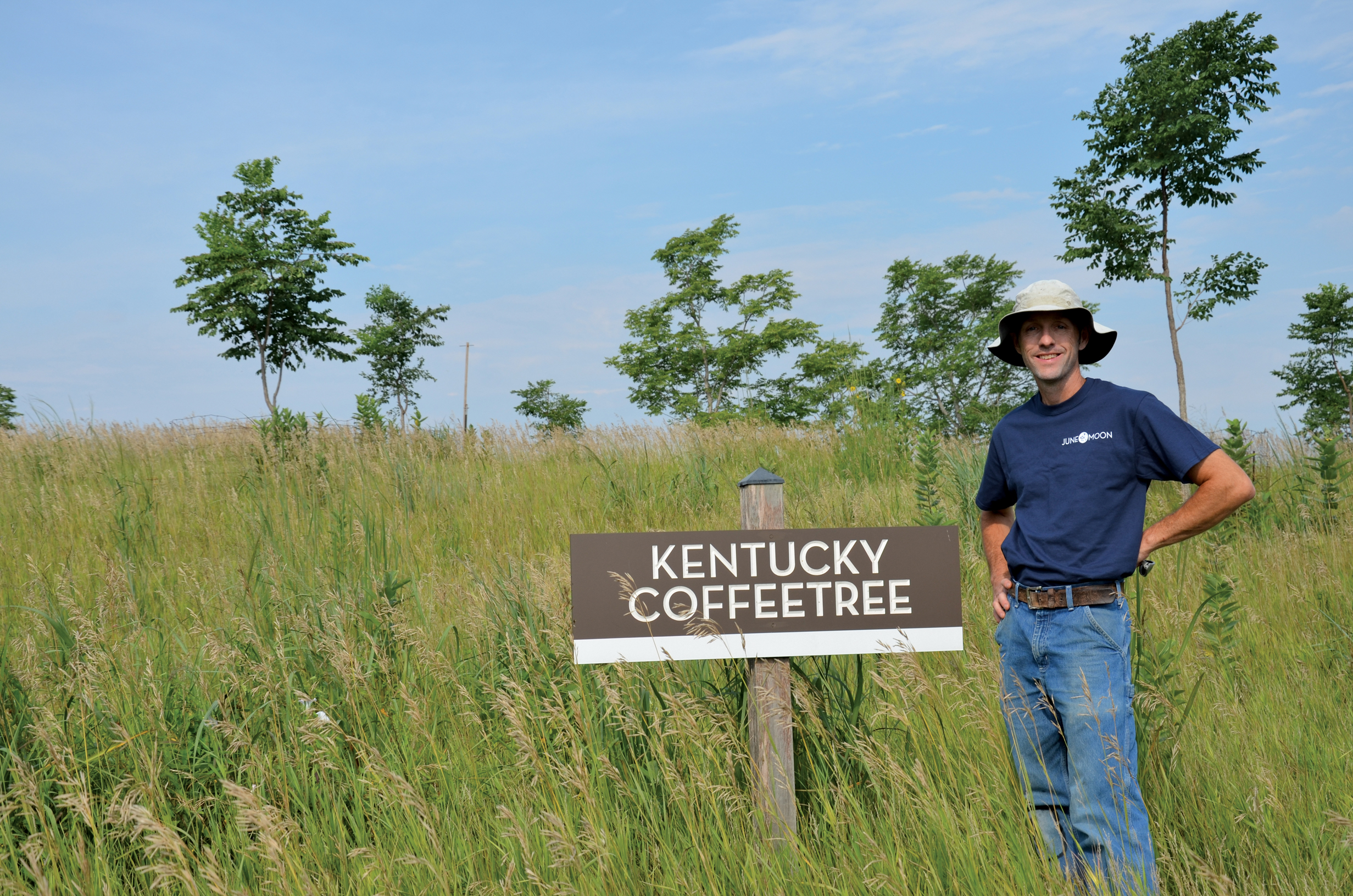 Photo of author standing beside sign for coffeetree collection