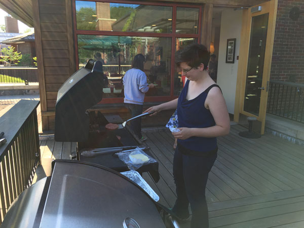 Graduate Student Becky Povlius BBQing on the back patio