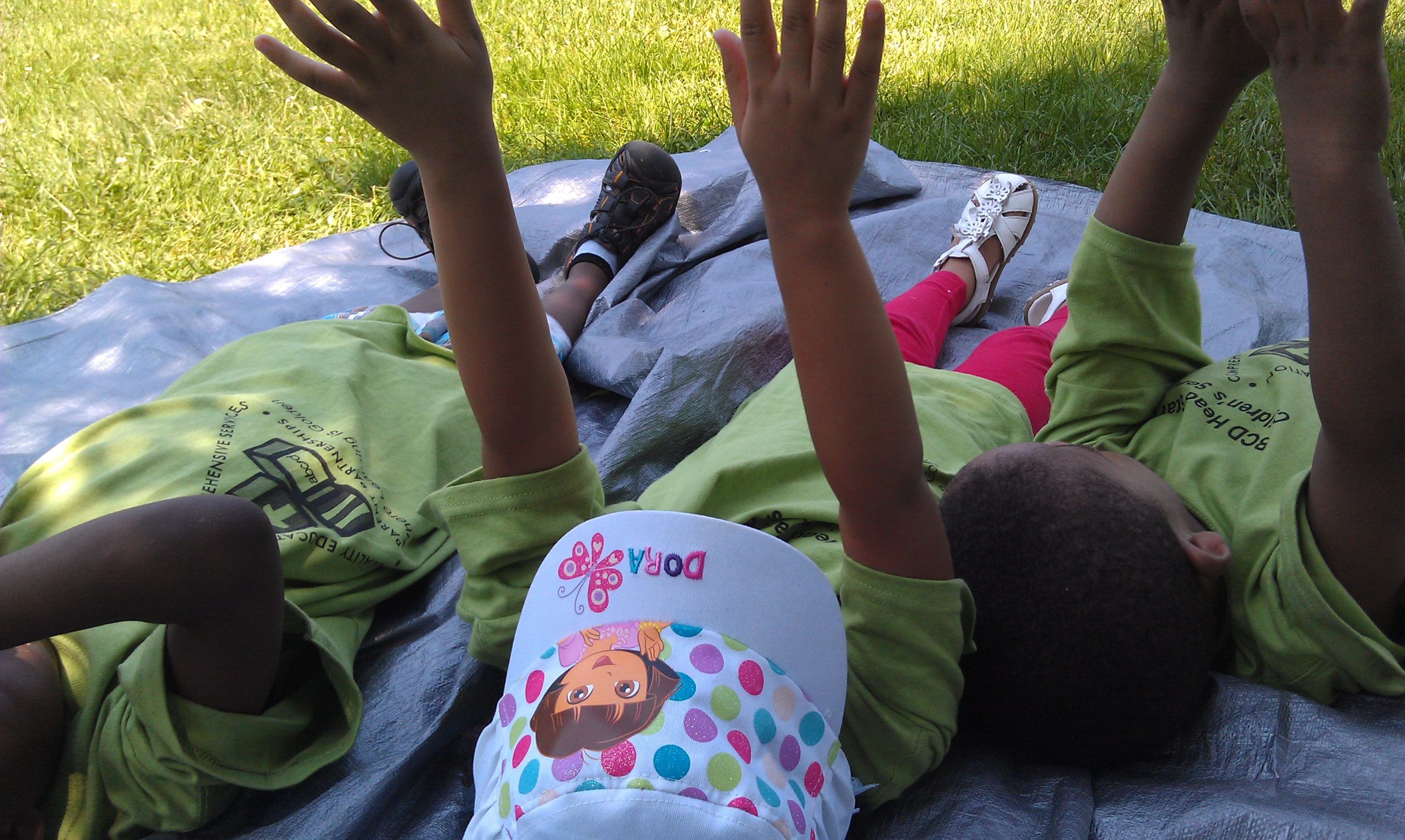 Children pretend to be trees reaching for the sunlight.