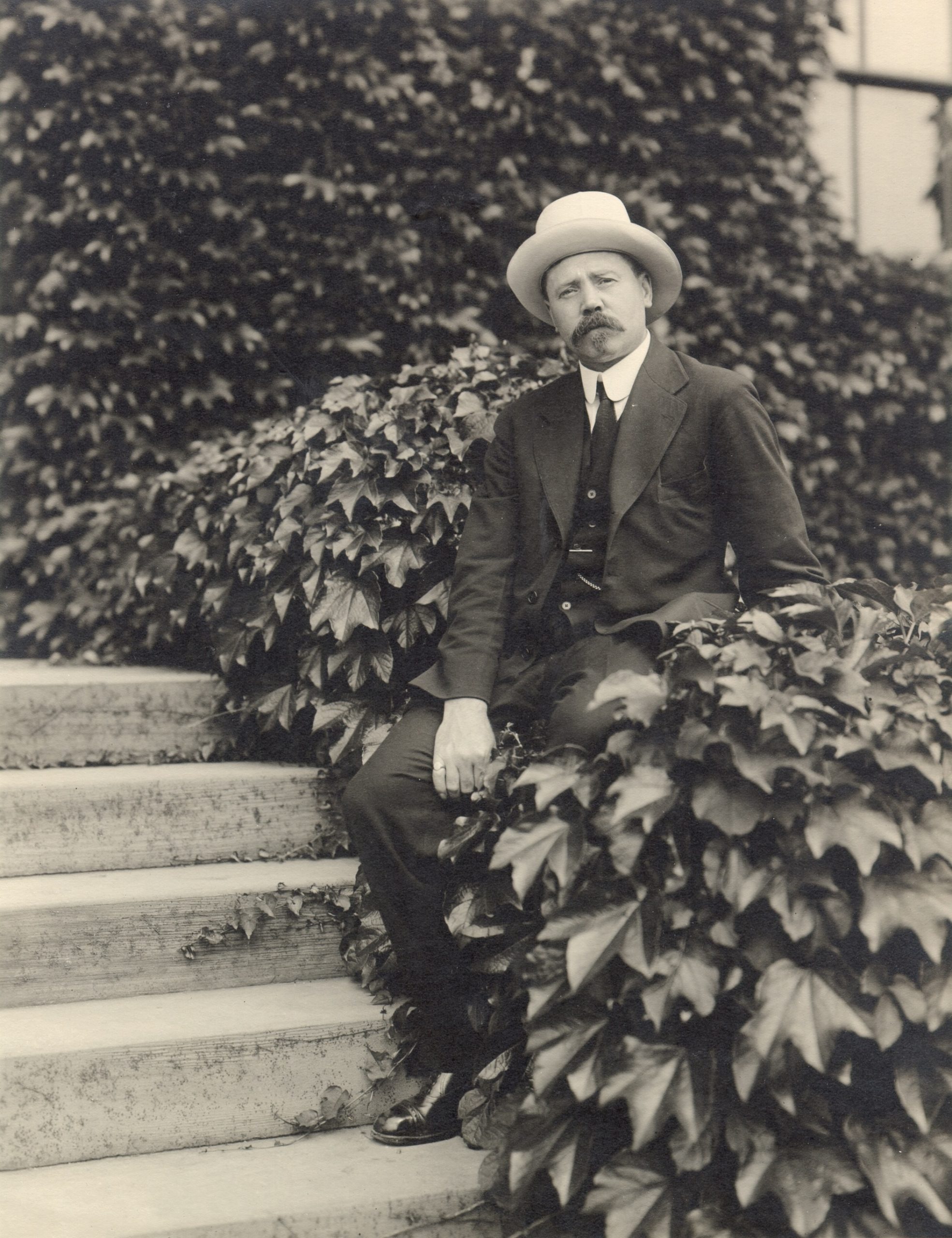 Ernest Henry Wilson seated in front of the Hunnewell Building.