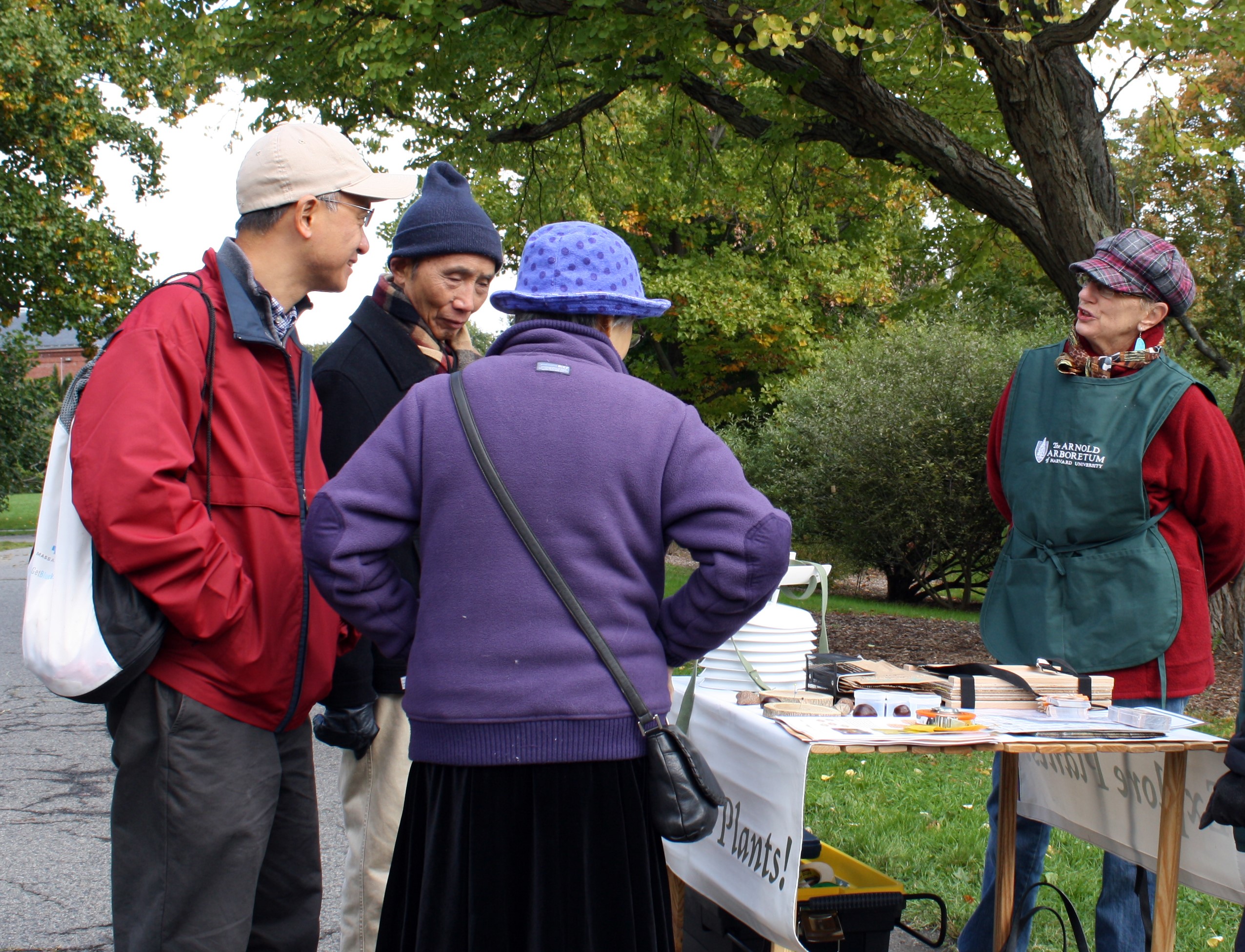 Arboretum volunteer chatting with visitors in the landscape.