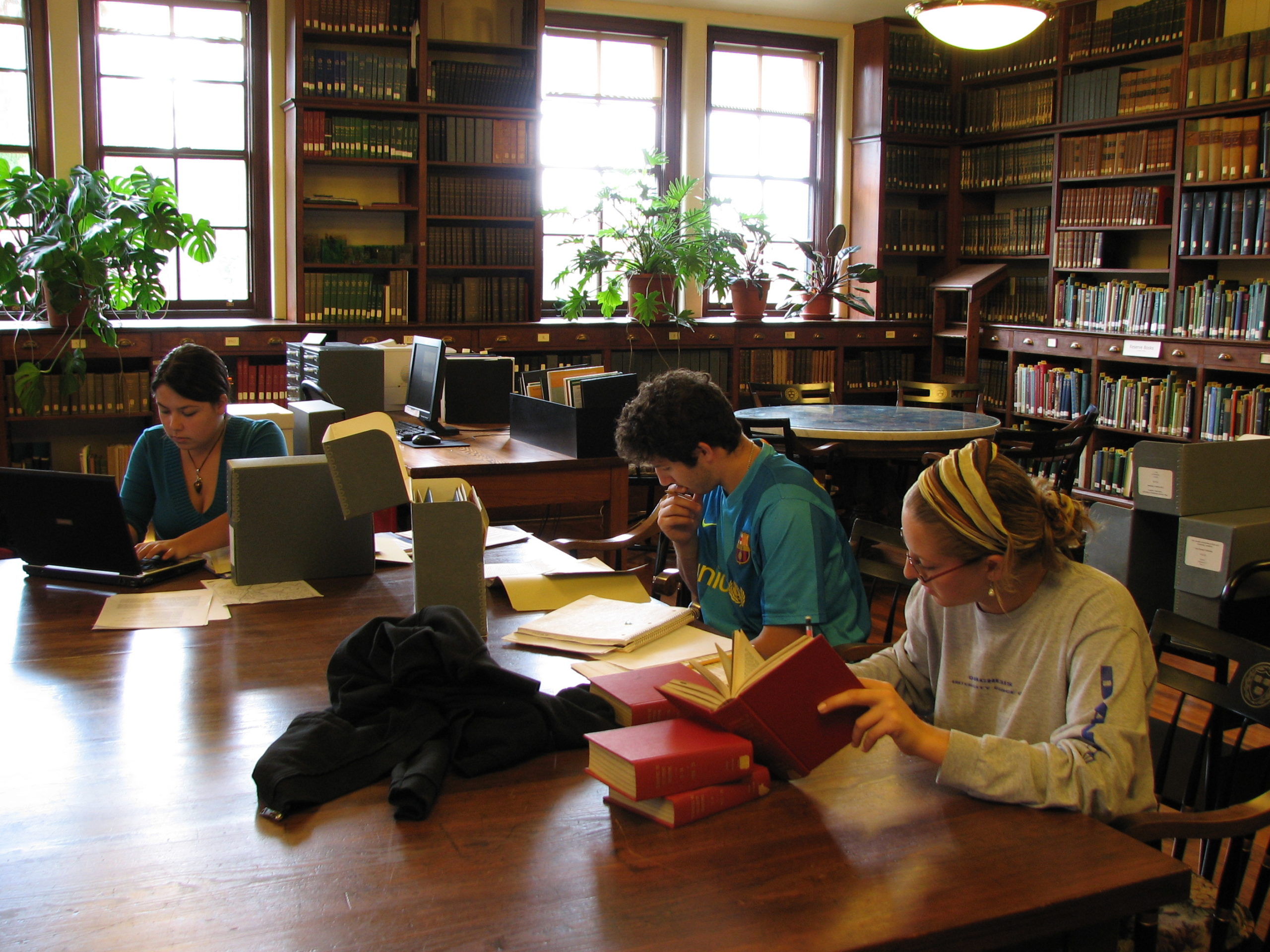 Students seated at the table in the Reading Room examining archival materials.