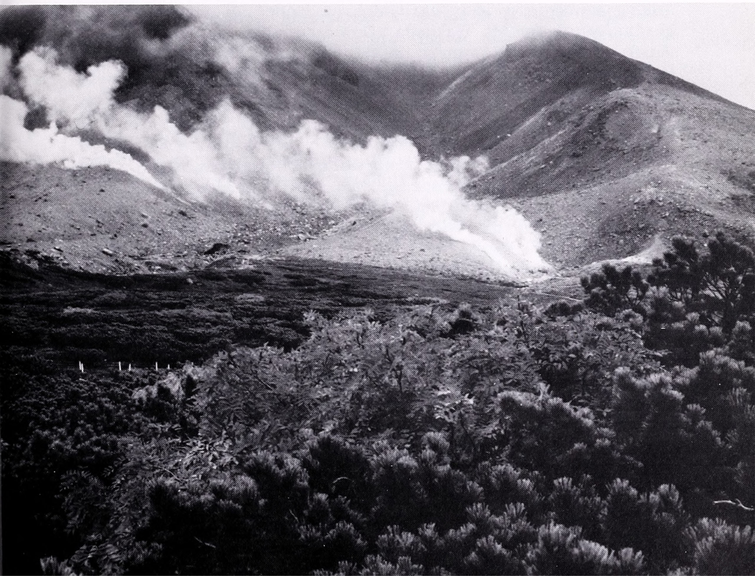 Black-and-white photograph of mountain landscape with low-handing clouds