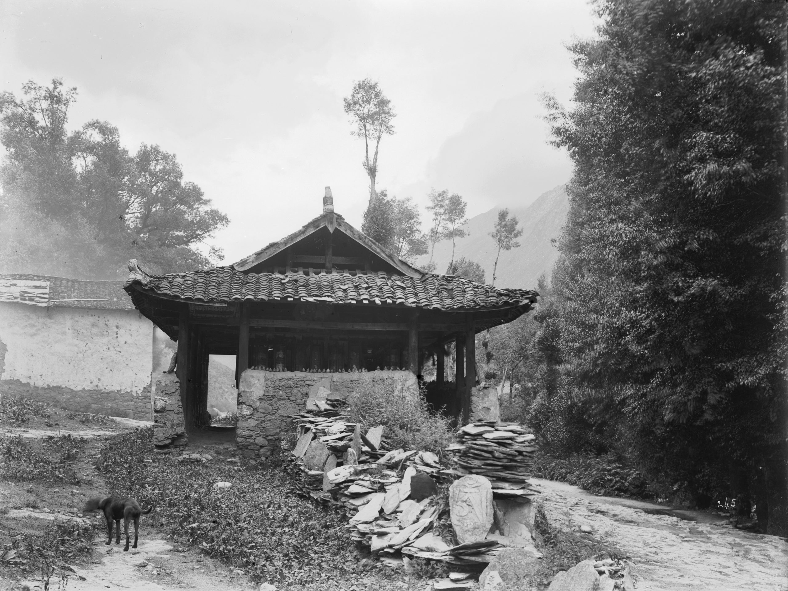 A building with prayer cylinders and Mani stones outside of a lamasery in Kangding (Tachien lu), Sichuan in a July 1908 photograph by Ernest Wilson.