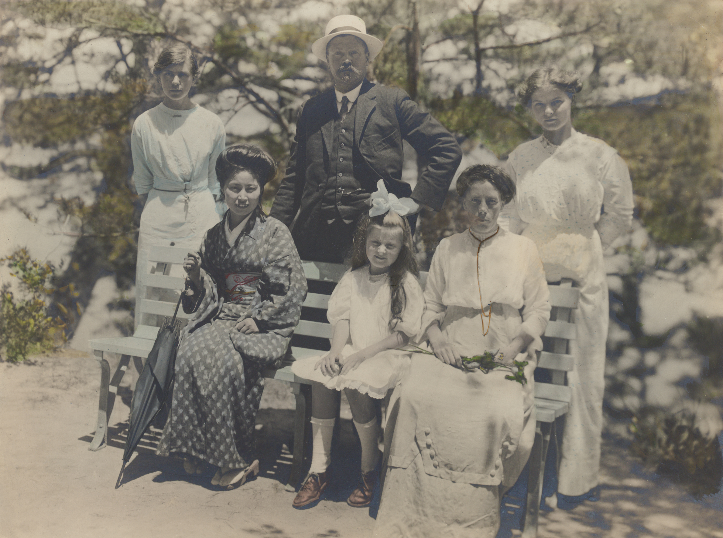 Ernest Wilson standing behind a bench between two unidentified women, with Amah, Muriel, and Ellen Wilson seated. Photographed in Japan in 1914.