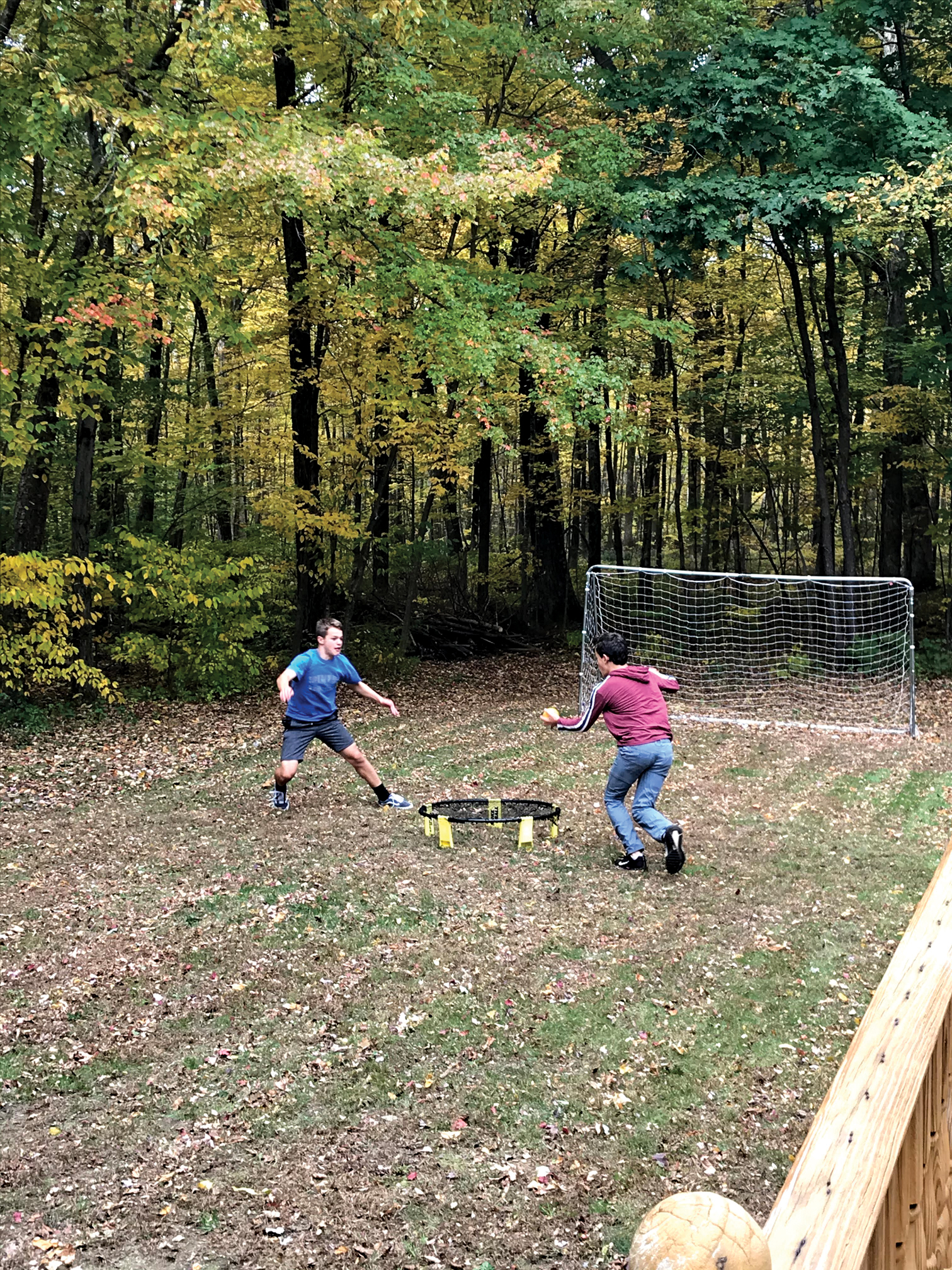 Photograph of two teenagers playing soccer in backyard