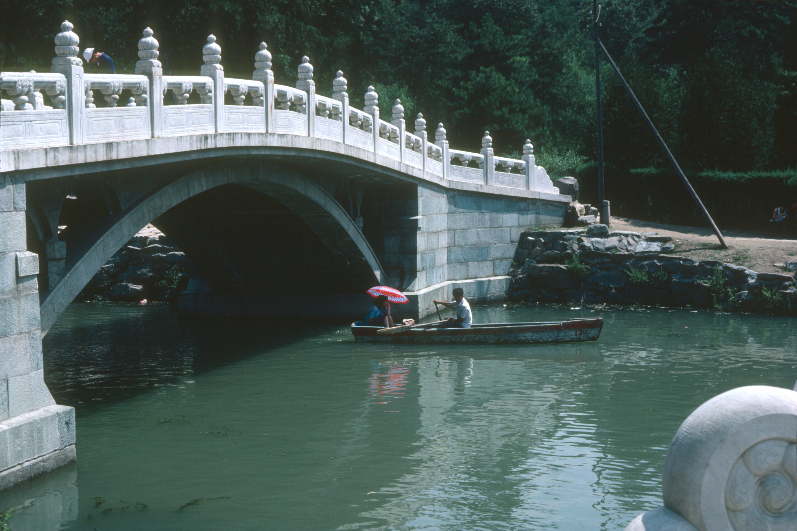 Boaters near a stone bridge at the Summer Palace, Beijing.