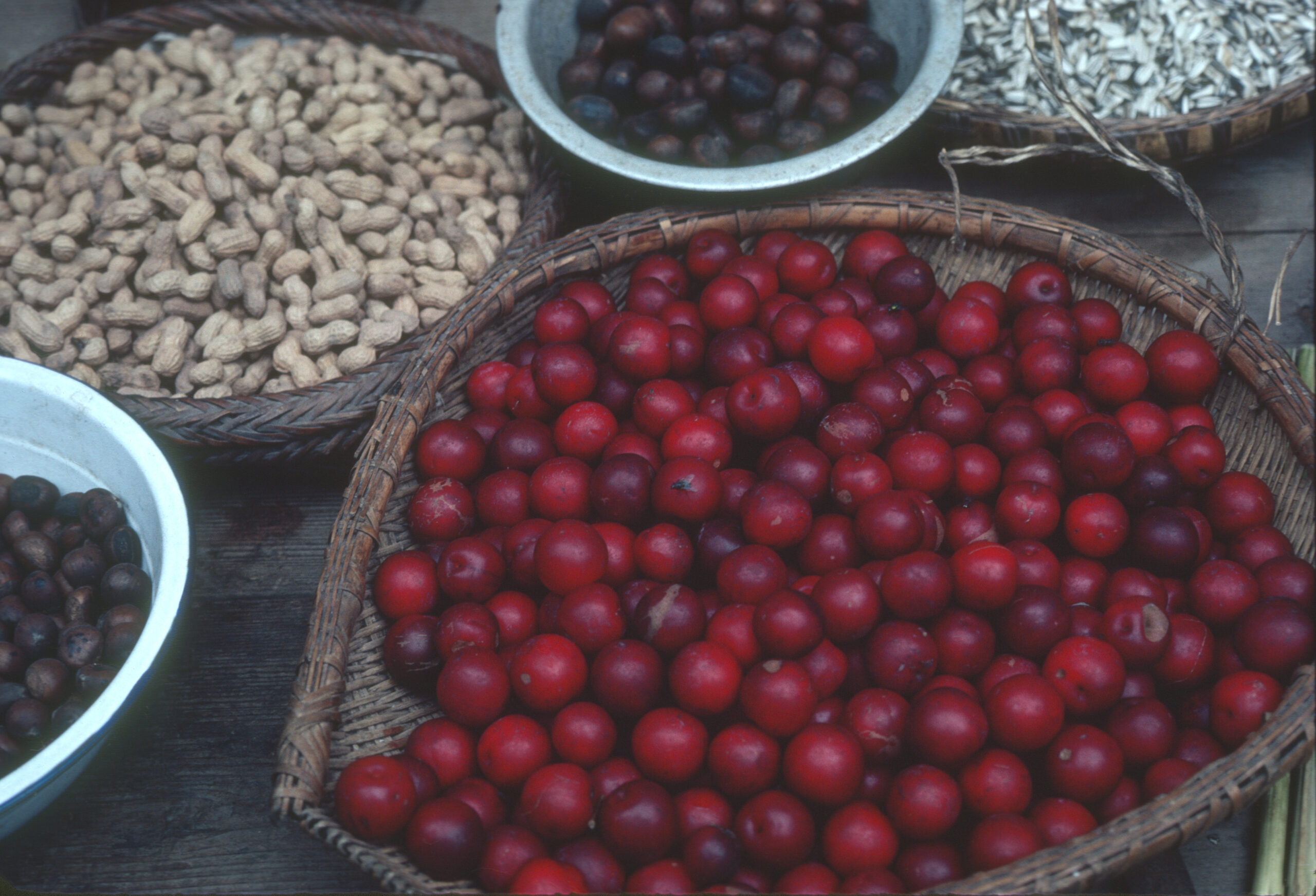 Hawthorn fruits, sunflower seeds, peanuts, and chestnuts for sale in baskets at the Lichuan market.