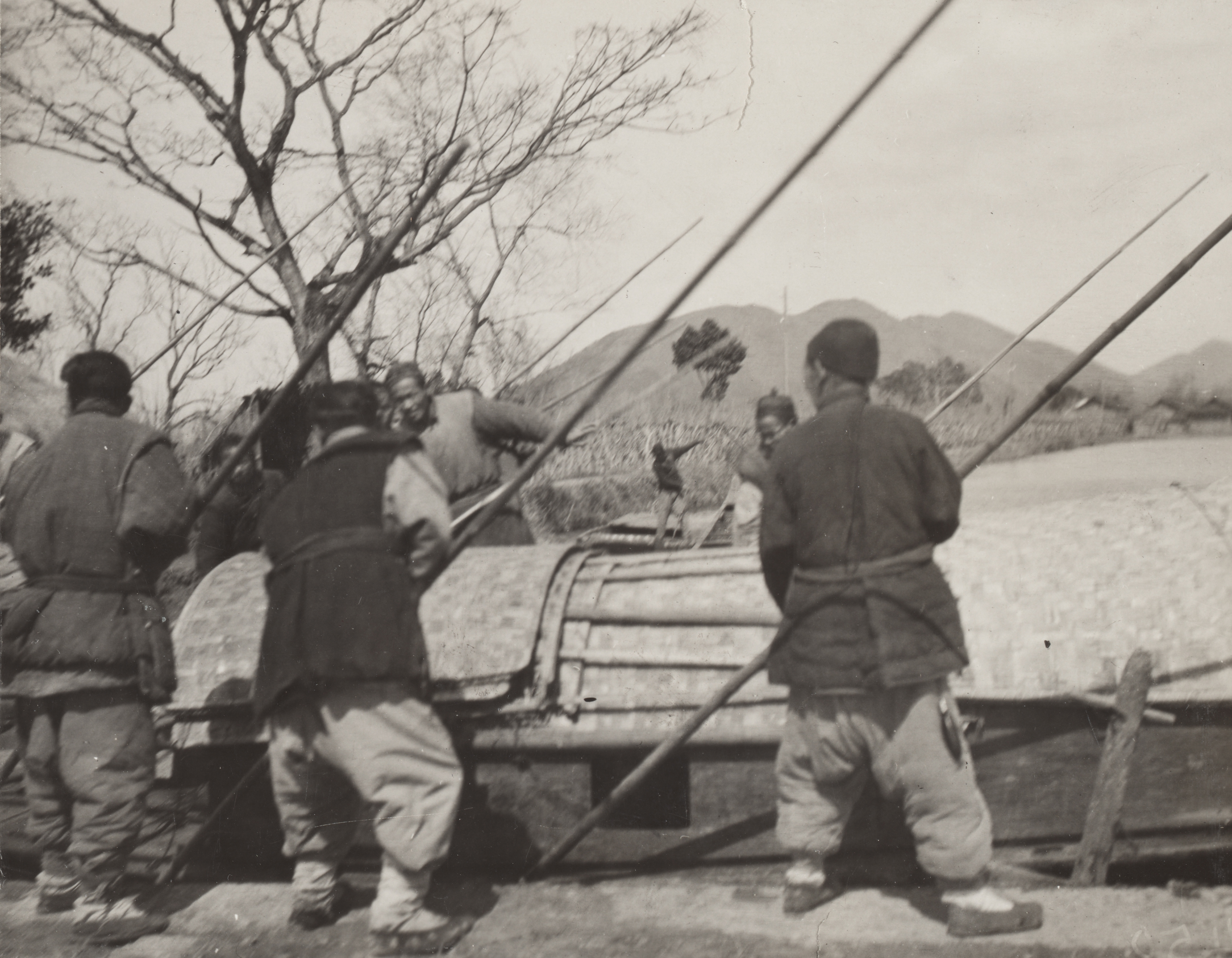 Boatmen easing their boat over a clay dam with poles, Tangqi (Tangshi), Zhejiang (Chekiang) Province. Photograph by Frank Meyer, March 1, 1906.