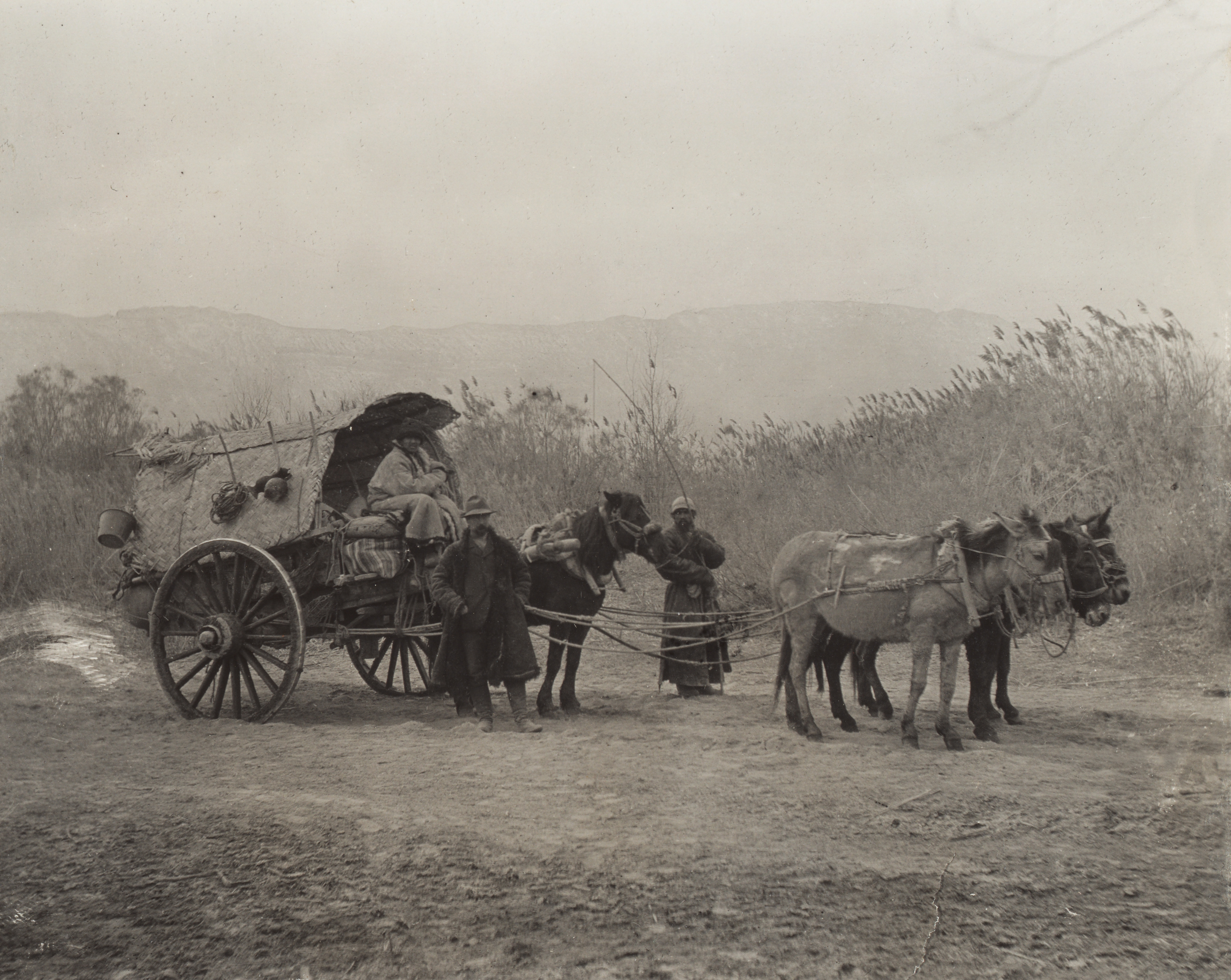 Frank Meyer's plant collecting team pose for his camera near Ure-dalik, Xinjiang. Standing in the front is his interpreter. Seated in the wagon is the guard, and standing in the rear is his horse handler. 