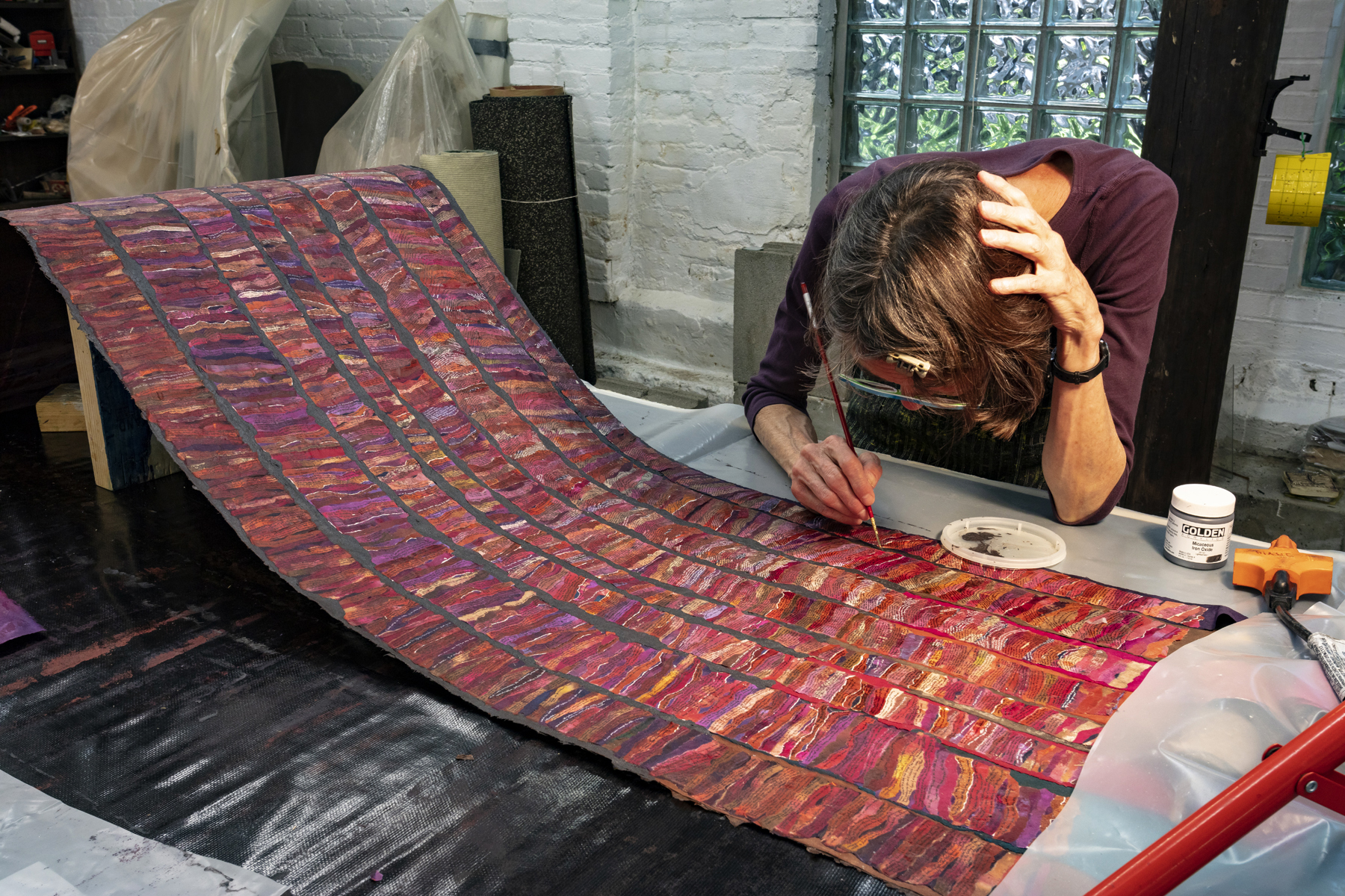 Aritst bent over art scroll and working