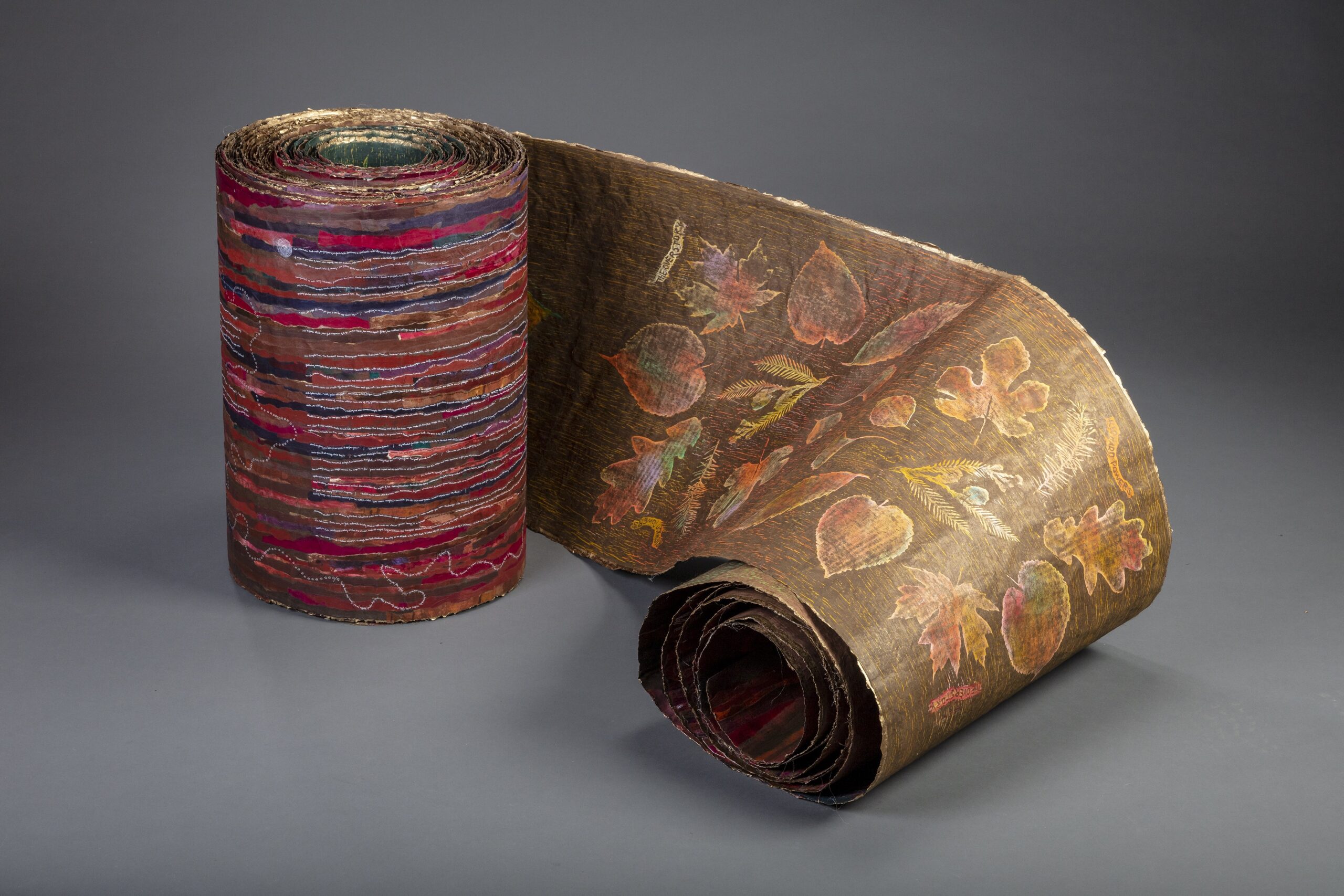 Art scroll mostly curled up, images of leaves and colorful design