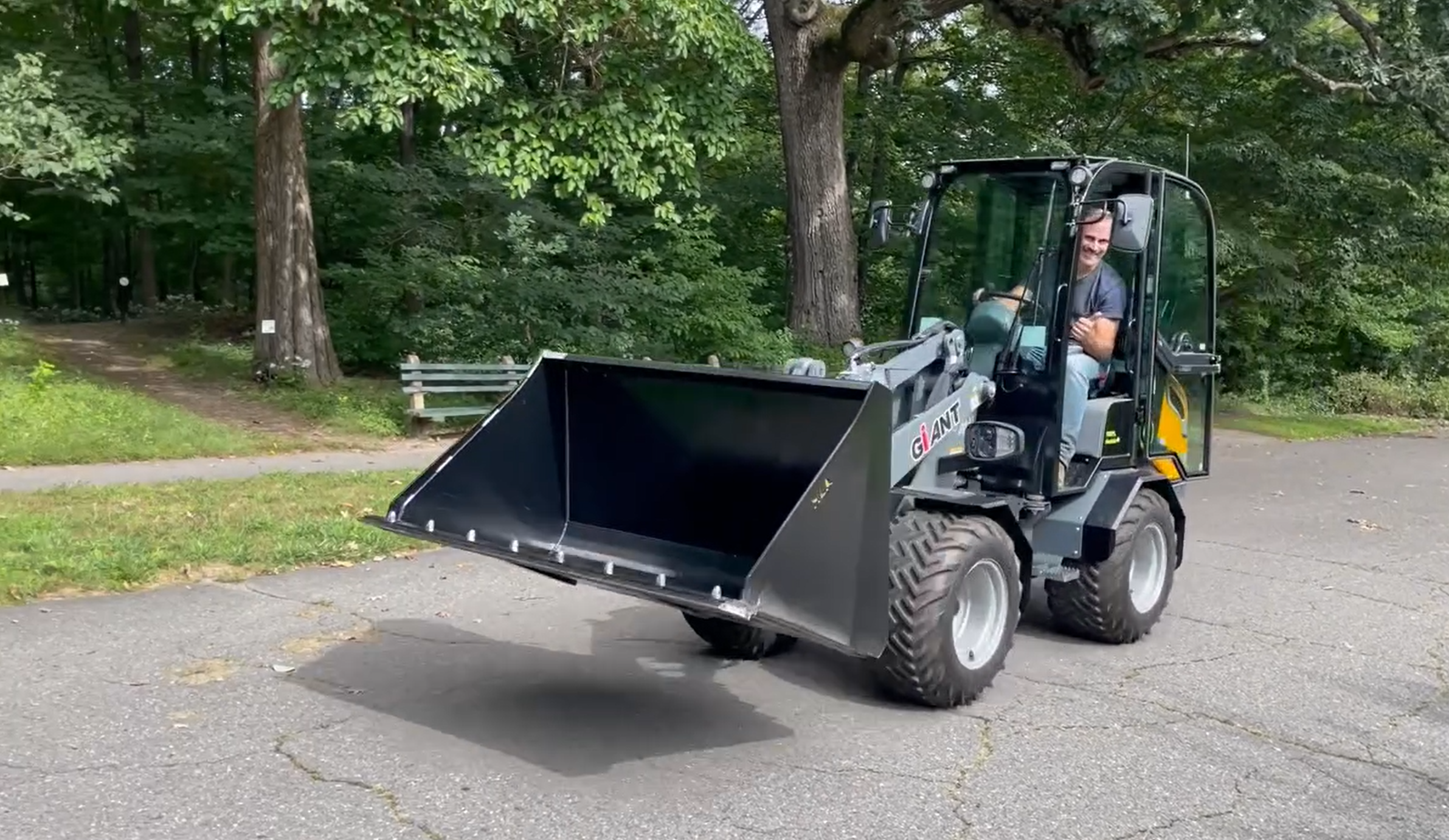 Man riding an electric compact loader vehicle.