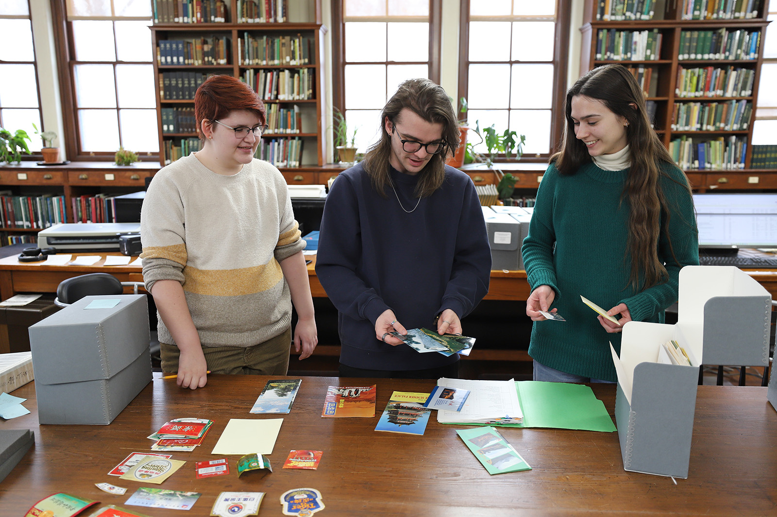 Bennington College interns Jester Wren (left) and Jay Clark (center) sort expedition materials and ephemera submitted by NACPEC expeditions participant Tony Aiello