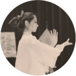 A black and white image of a woman in a white robe doing tai chi